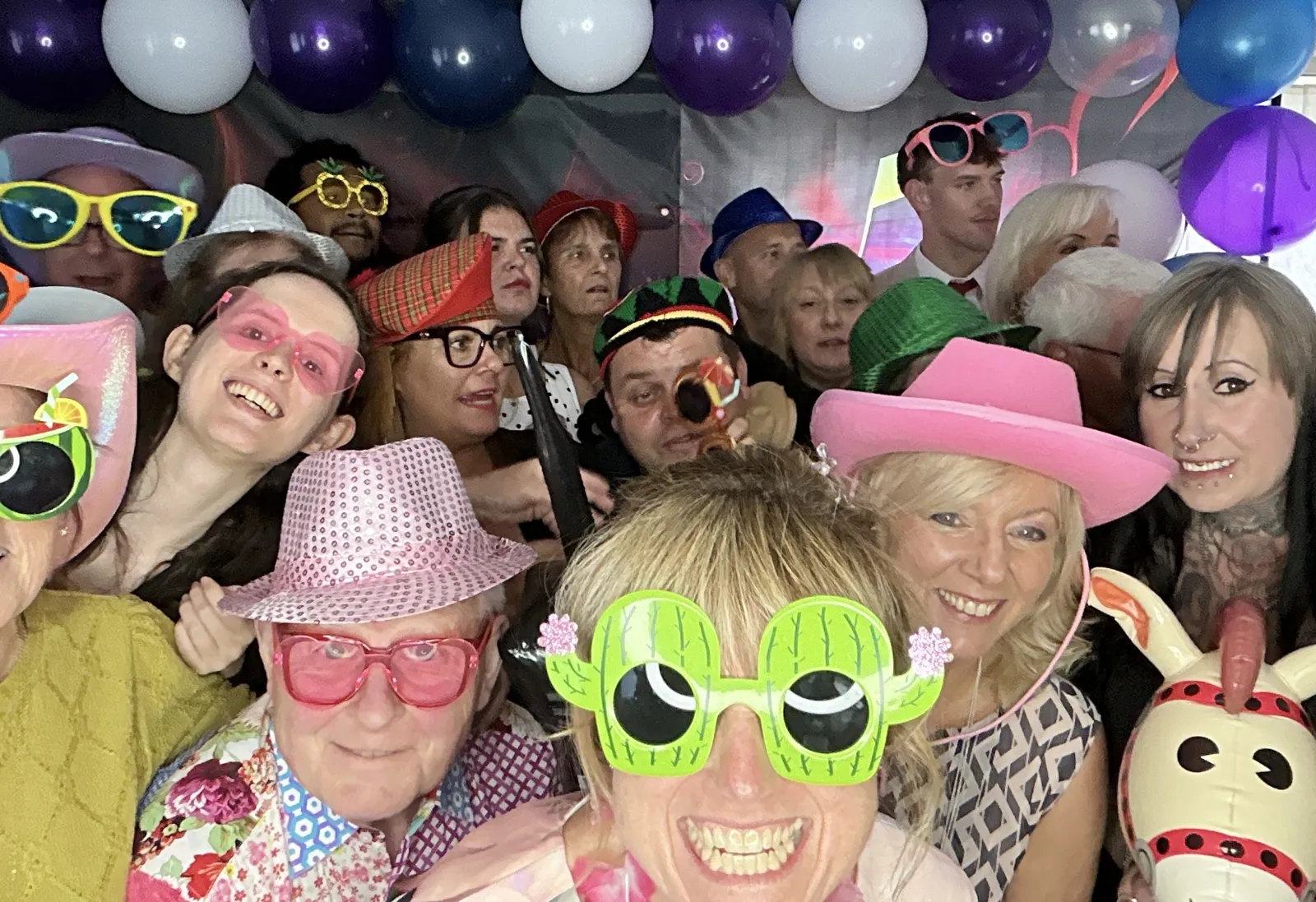 Guests in props and hats filling the photo booth